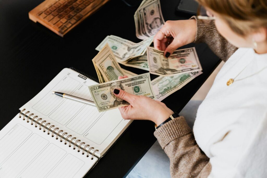 a person counting her money on the table